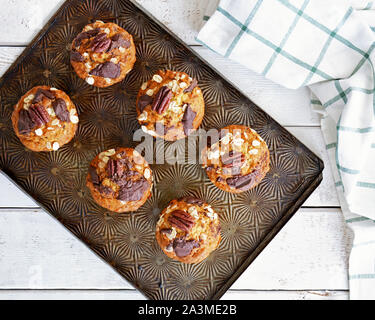 Frisch gebackene Banane Haferflocken Pecan und Schokolade Muffins auf vintage Backblech Schuß in natürlichem Licht in flache Komposition legen. Gesunde und nahrhafte s Stockfoto