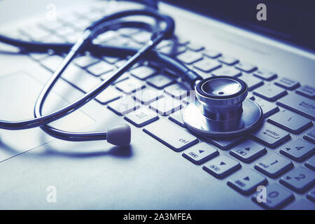 Medizinische Stethoskop auf Laptop Tastatur. Computer Diagnose- oder e-Health Concept Stockfoto