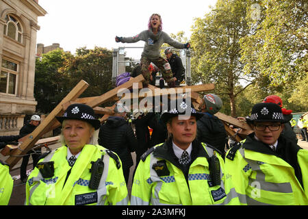 Polizei surround Demonstranten auf einem Holz- Struktur auf Vogelkäfig Weg, während der dritte Tag der Auslöschung Rebellion (XR) Protest in Westminster, London. Stockfoto