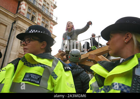 Polizei surround Demonstranten auf einem Holz- Struktur auf Vogelkäfig Weg, während der dritte Tag der Auslöschung Rebellion (XR) Protest in Westminster, London. Stockfoto