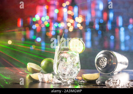 Glas mit alkoholisches Getränk mit Kalk, Eis und Rosmarin Stockfoto