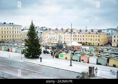 Helsinki, Finnland, 19.12.2018: Weihnachtsmarkt mit Weihnachtsbaum auf den Senatsplatz mit Schnee bedeckt. Urlaub Karussell und Menschen zu Fuß. Stockfoto