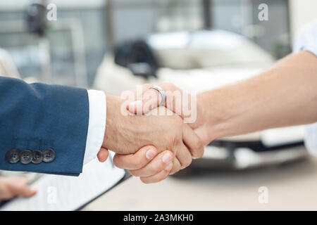 Zwei Männer die Hände schütteln, stehend im Auto Salon Stockfoto