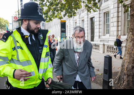 London, Großbritannien. 9. Oktober, 2019. John lynes, eine 91-jährige Klima Aktivist aus Aussterben Rebellion ist festgehalten durch Polizeibeamte mit Abschnitt 14 der öffentlichen Ordnung von 1986 nach dem Blockieren Whitehall am dritten Tag der Internationalen Rebellion Proteste eine Erklärung der Regierung, ein Klima und ökologische Not zu verlangen, die Verpflichtung, den Verlust der biologischen Vielfalt aufzuhalten und net Keine Co2-Emissionen bis 2025 und für die Regierung zu erstellen und durch die Entscheidungen der Bürger" auf Klima und ökologische Gerechtigkeit geführt werden. Credit: Mark Kerrison/Alamy leben Nachrichten Stockfoto