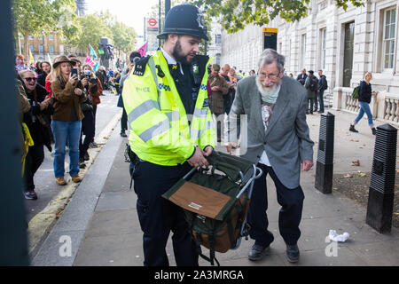 London, Großbritannien. 9. Oktober, 2019. John lynes, eine 91-jährige Klima Aktivist aus Aussterben Rebellion ist festgehalten durch Polizeibeamte mit Abschnitt 14 der öffentlichen Ordnung von 1986 nach dem Blockieren Whitehall am dritten Tag der Internationalen Rebellion Proteste eine Erklärung der Regierung, ein Klima und ökologische Not zu verlangen, die Verpflichtung, den Verlust der biologischen Vielfalt aufzuhalten und net Keine Co2-Emissionen bis 2025 und für die Regierung zu erstellen und durch die Entscheidungen der Bürger" auf Klima und ökologische Gerechtigkeit geführt werden. Credit: Mark Kerrison/Alamy leben Nachrichten Stockfoto