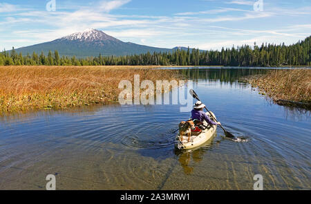 Kajakfahrer auf Hosmer See im Oregon Cascade Mountains im frühen Herbst. Mount Bachelor ist im Hintergrund. Stockfoto