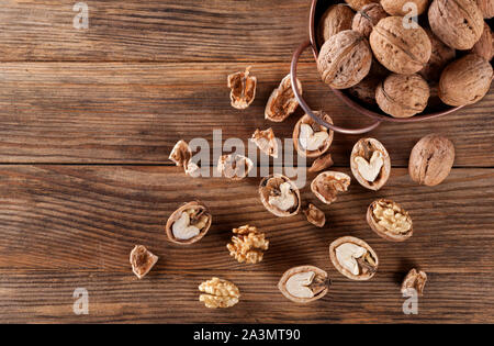 Walnüsse. Ganze Nussbaum, geschält, Nussbaum, Nussbaum, Nussbaum, Nussbaum shell kernel Gießen von dekorativen Schaufel auf der Holzoberfläche. kreativen Hintergrund. Stockfoto