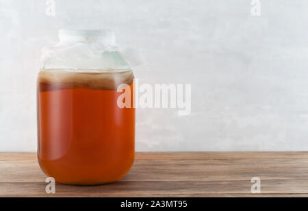 Hausgemachte Rauschtrank Kombucha im Glas auf einem Holztisch. Gesunde organische fermentierte probiotische Drink. Healthcare Konzept Hintergrund. ICH Stockfoto