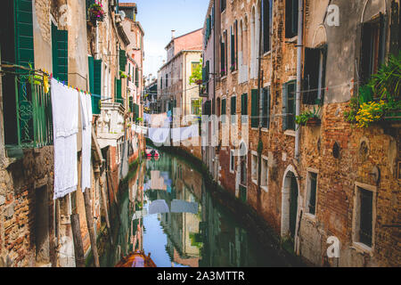 Romantischer Kanal in Venedig, rustikale Häusermauern mit Wäscheleine und Blunmen Stockfoto