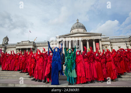 London, Großbritannien. 9. Oktober, 2019. Klima Aktivisten vom Aussterben Rebellion Rote Brigade, die von den Aktivisten in den Farben der blauen und grünen Brigaden gekleidet ergänzt, sammeln auf dem Trafalgar Square am dritten Tag der Internationalen Rebellion Proteste eine Erklärung der Regierung, ein Klima und ökologische Not zu verlangen, die Verpflichtung, den Verlust der biologischen Vielfalt aufzuhalten und net Keine Co2-Emissionen bis 2025 und für die Regierung zu erstellen und durch die Entscheidungen der Bürger" auf Klima und ökologische Gerechtigkeit geführt werden. Credit: Mark Kerrison/Alamy leben Nachrichten Stockfoto