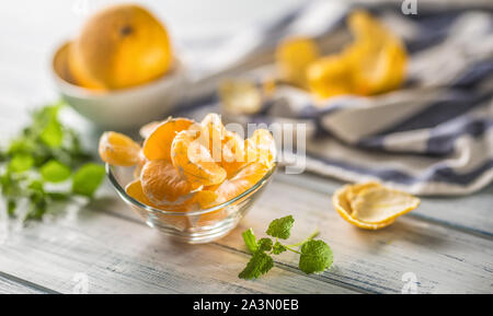 Mit Mandarinen schälen und mellisa Kräuter auf Tisch. Frische tropische Frucht auf Holzbrett Reif Stockfoto