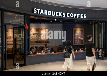 Fußgänger vorbei an einer amerikanischen Kaffee und Kaffeehaus Kette, Starbucks Stores in Guangzhou. Stockfoto