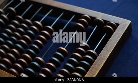 Vintage Holz- Abacus hautnah. Zählen Holz- Knöchel. Ein Teil der alten Ende des Abacus auf dunkelblauem Hintergrund Stockfoto