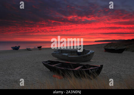 Traditionelle schwarze Farbe Fischerboot auf Sandstrand in Baabe, die Fischer in den Morgen mit orange Sunrise, Insel Rügen, Ostsee, Deutschland. Stockfoto