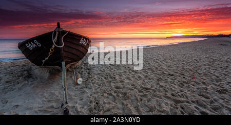 Traditionelle schwarze Farbe Fischerboot auf Sandstrand in Baabe, die Fischer in den Morgen mit orange Sunrise, Insel Rügen, Ostsee, Deutschland. Stockfoto