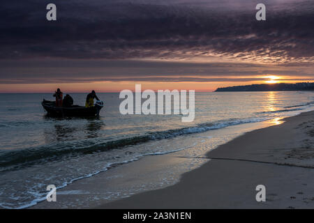 Traditionelle schwarze Farbe Fischerboot auf Sandstrand in Baabe, die Fischer in den Morgen mit orange Sunrise, Insel Rügen, Ostsee, Deutschland. Stockfoto