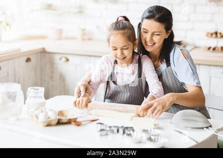 Mutter und Tochter heraus rollen den Teig für Cookies zusammen Stockfoto