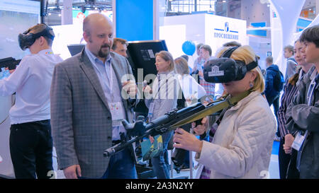 Frau mit Virtual reality Headset und spielen in den shooter spiel Stockfoto