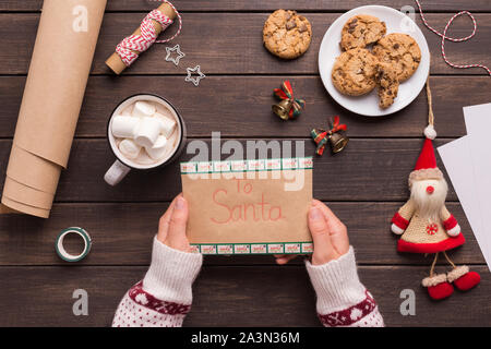 Frau in Pullover Holding bereit Brief für Santa Stockfoto