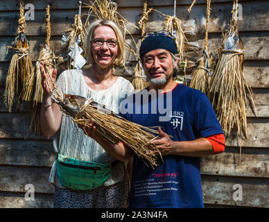 Die Journalistin Angela Berg neben Yasuhisa Seriwaza mit dem traditionellen shio-Katsuo, dem Bonito im Bast-Kleid. Yasuhisa Serizawas Katsuobushi-Manufaktur in Nishiizu-Cho, Shizuoka, Japan Stockfoto