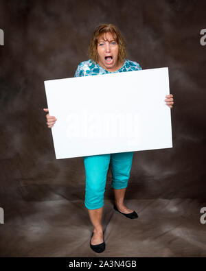 Vertikaler wütend schreiende Frau Holding ein leeres Zeichen. Braunen Hintergrund. Stockfoto