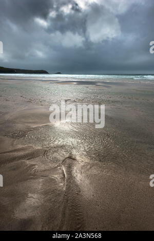 Dunkle Regenwolken über eine einsame Fistral Beach in Newquay in Cornwall. Stockfoto