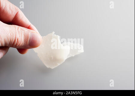 Hand mit gehobeltem Parmesan Stockfoto