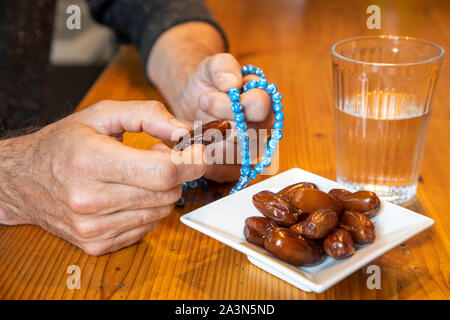 Symbolbild Fastenbrechen im Fastenmonat Ramadan, für Muslime, Wasser und Datteln nach Sonnenuntergang, als die erste Mahlzeit am Tag, Stockfoto