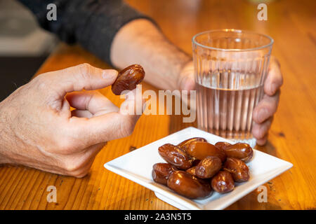 Symbolbild Fastenbrechen im Fastenmonat Ramadan, für Muslime, Wasser und Datteln nach Sonnenuntergang, als die erste Mahlzeit am Tag, Stockfoto