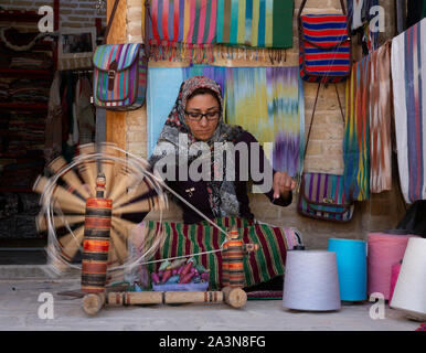 Isfahan, Iran - 2019-04-12 - Frau spinnt Garn auf eine manuelle Spinner. Stockfoto