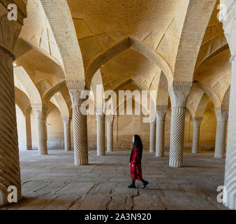 Shiraz, Iran - 2019-04-08 - Frau Spaziergänge durch kannelierte Säulen der Moschee Vakil. Stockfoto