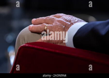 Hand des Mannes in Ruhe auf dem Knie, mit goldenem Ehering/Band am Ringfinger. Stockfoto