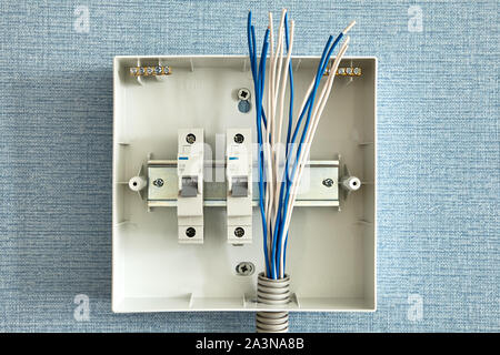 Installation einer Steuerkonsole für die Stromversorgung in einem Wohnhaus. Installieren der Leistungsschalter für elektrische Verkabelung. Drähte an den swit angeschlossen Stockfoto