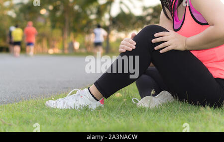 Knieverletzungen. Young Sport Frau knie Holding mit ihren Händen in den Schmerz nach Leiden Muskelverletzungen während eines laufenden Training im Park. Healthcare eine Stockfoto