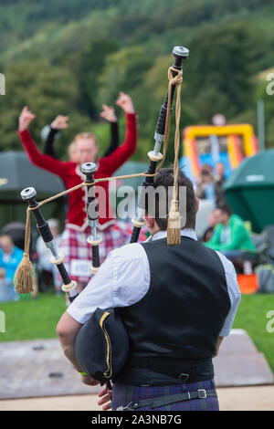 Piper und Highland Dancing Girls in der Highland Games in Peebles. Peebles, Scottish Borders, Schottland Stockfoto