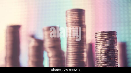 Stapel von goldenen Münzen gegen eine Disco style Hintergrund, geringe Tiefenschärfe, Farbe Tonen angewendet. Stockfoto