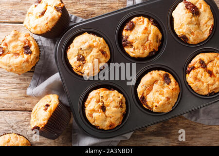 Frisch gebackene Muffins mit getrockneten Tomaten und Cheddar Käse close-up in einer Auflaufform auf den Tisch. Horizontal oben Ansicht von oben Stockfoto