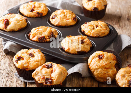 Frisch gebackene Muffins mit getrockneten Tomaten und Cheddar Käse close-up in einer Auflaufform auf den Tisch. Horizontale Stockfoto