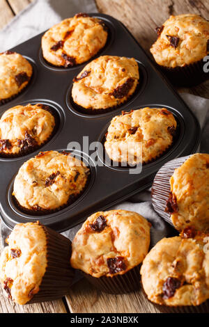 Muffins mit getrockneten Tomaten und Cheddar Käse close-up in einer Auflaufform auf den Tisch. Vertikale Stockfoto