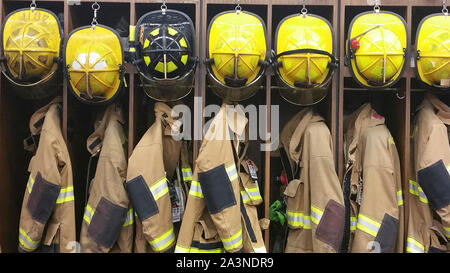Eine Aufstellung der Helme der Feuerwehrleute und Wahlbeteiligung Gang in einem Schließfach am Bahnhof ein freiwilliger Feuerwehrmann Stockfoto