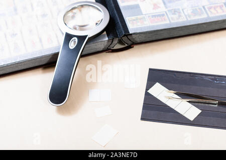 Philatelie - Briefmarken und Philatelie auf hellem Holztisch Stockfoto