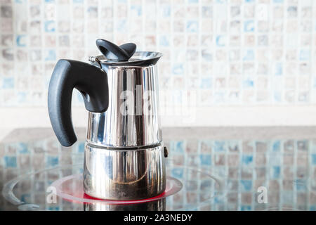 Mit der Zubereitung von Kaffee mit Druck moka Topf auf Keramik elektrische Reichweite zu Hause Küche Stockfoto