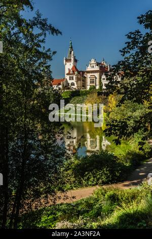 Prag, tschechische Republik - 7. Oktober 2019: Szenische Ansicht der berühmten romantischen Schloss über einen See mit seinem Spiegelbild im Wasser, mit grünen Bäumen umgeben. Stockfoto