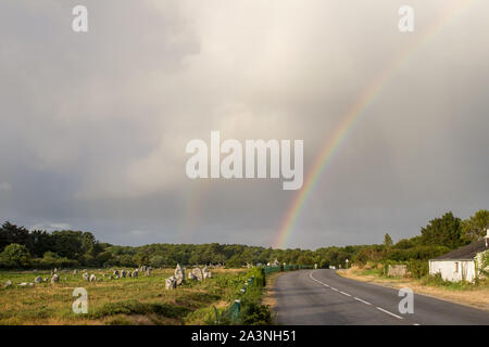 Regenbogen über Ausrichtungen der Menec-Zeilen der Menhire - Steine - in der Nähe von Carnac in der Bretagne, Frankreich Stockfoto