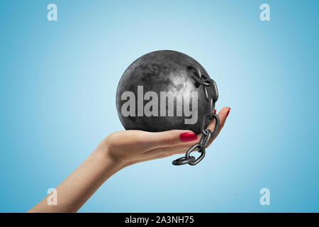 Seite Nahaufnahme des Woman's Hand nach oben gedrückt und schwarze Kugel und Kette von blauen Farbverlauf Hintergrund. Stockfoto