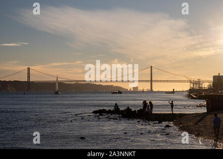 Oktober 6th, 2019, Lissabon, Portugal - Menschen Bilder aufnehmen in der Nähe des Flusses Tagus mit am 25. April Bridge im Hintergrund. Stockfoto