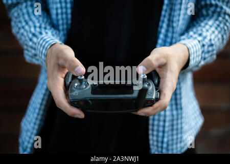 Person, die einen drahtlosen gadget Fernbedienung mit Joystick und Antenne Stockfoto