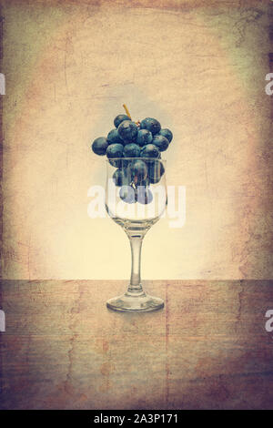 Konzeptionelle Idee der Trauben in den Wein Glas als Rohstoffe anstelle von Endprodukt mit einem Vintage Filter Stockfoto