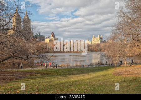 Der Central Park, New York City Tageslicht mit Menschen zu Fuß, New York Skyline, Reflexion im Wasser, Wolken und Bäume Stockfoto