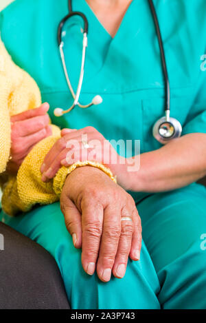 Junge Arzt, helfende Hände für ältere Frau Stockfoto